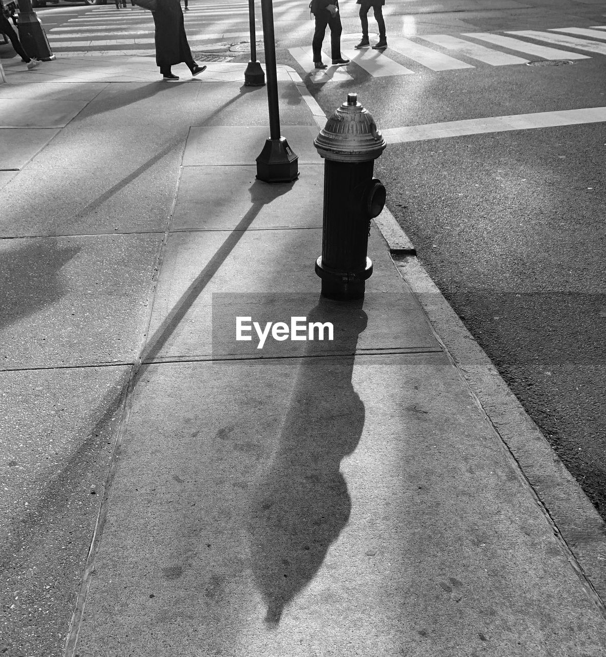 Low section of people walking on street in city