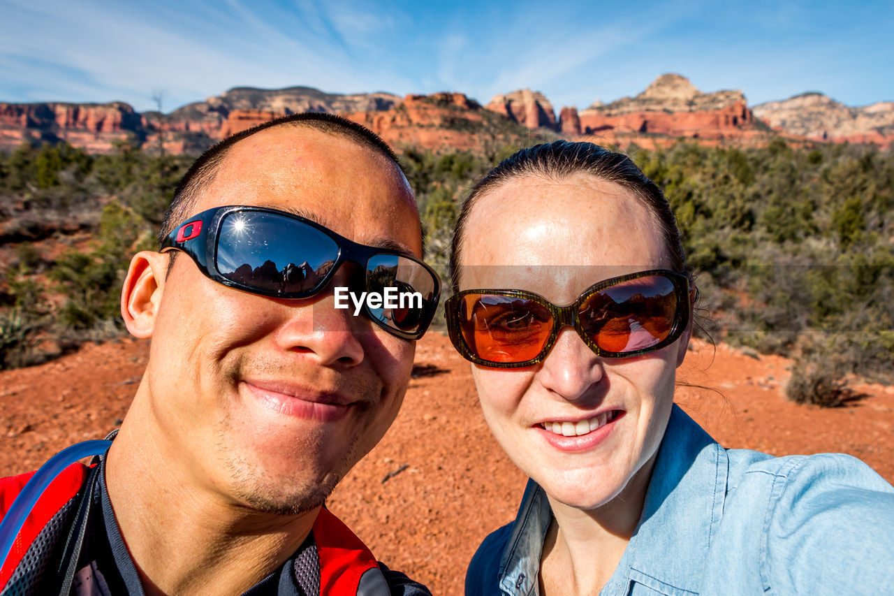 Portrait of smiling man and woman wearing sunglasses