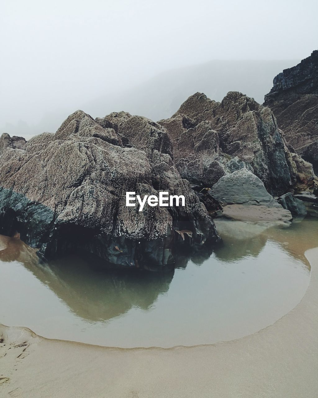 Scenic view of rock formation in sea against sky