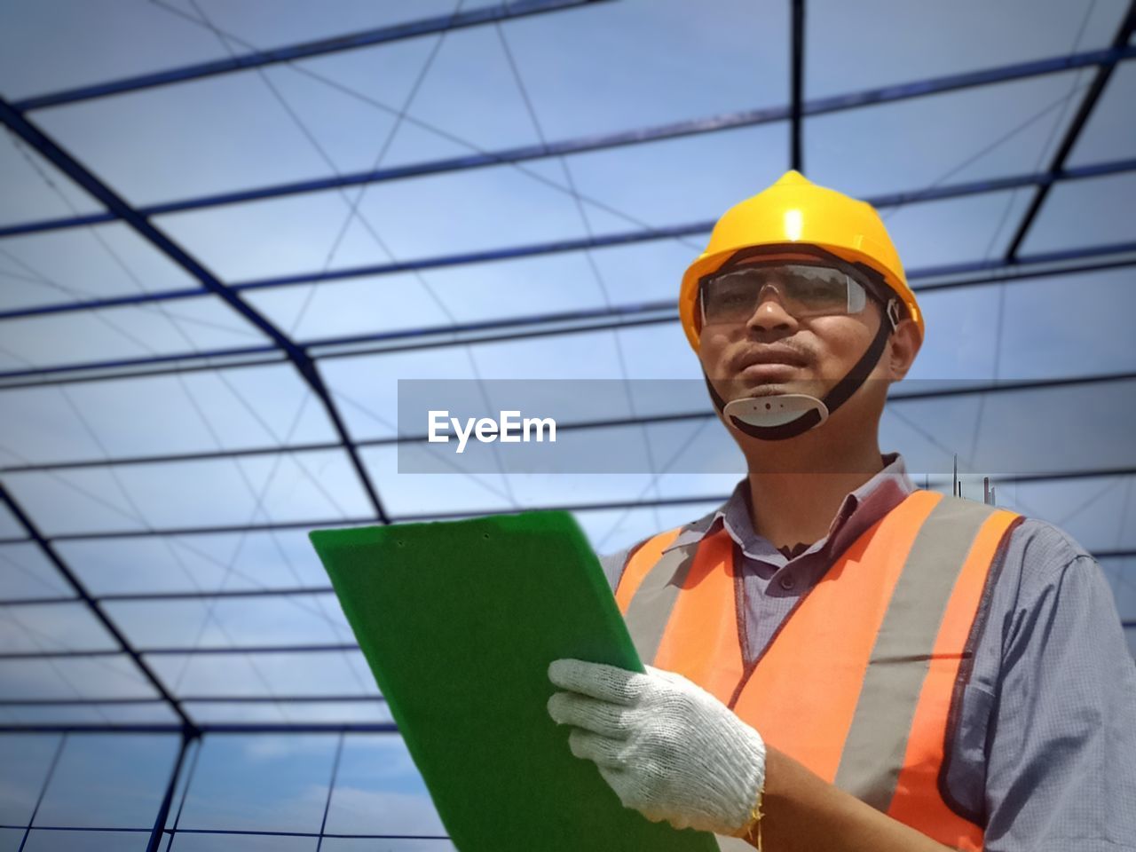 LOW ANGLE VIEW OF MAN WORKING WITH ORANGE UMBRELLA