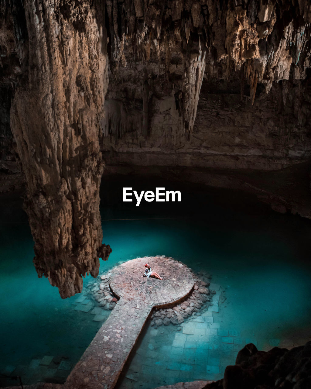 High angle view of woman sitting on pier in cave