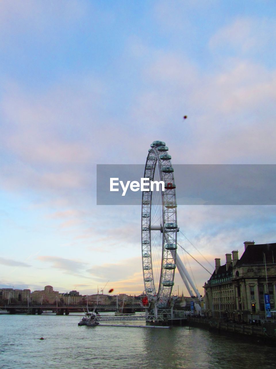 FERRIS WHEEL IN RIVER AGAINST SKY