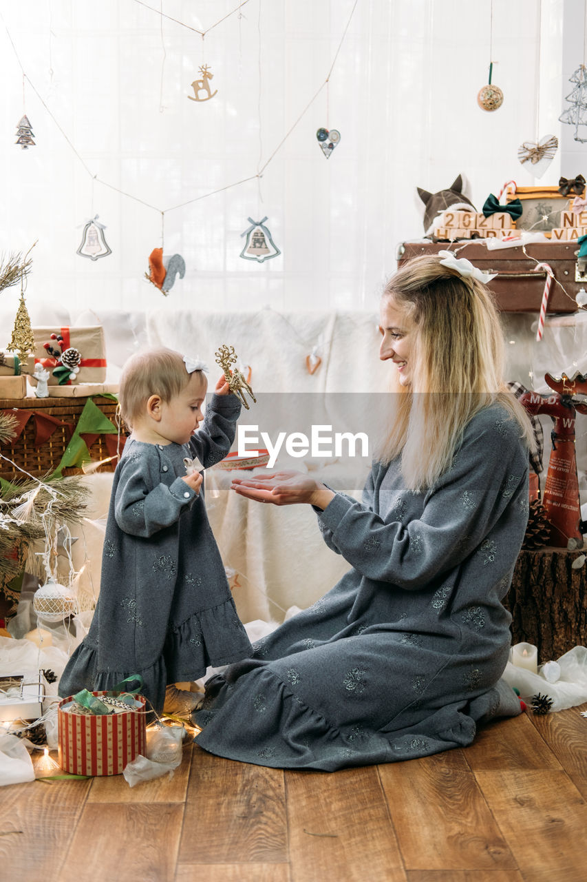 Smiling mother with daughter amidst decoration at home