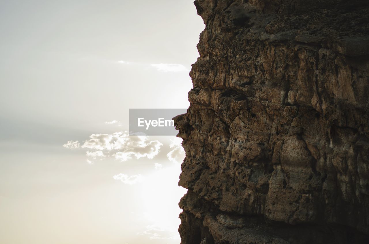 Rock formation by sea against sky