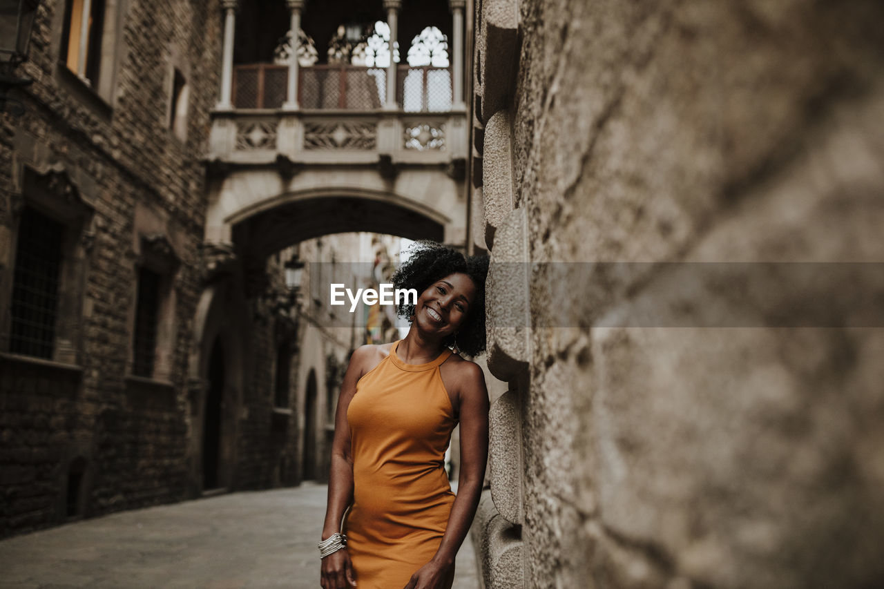 Smiling woman leaning on wall, barcelona, spain