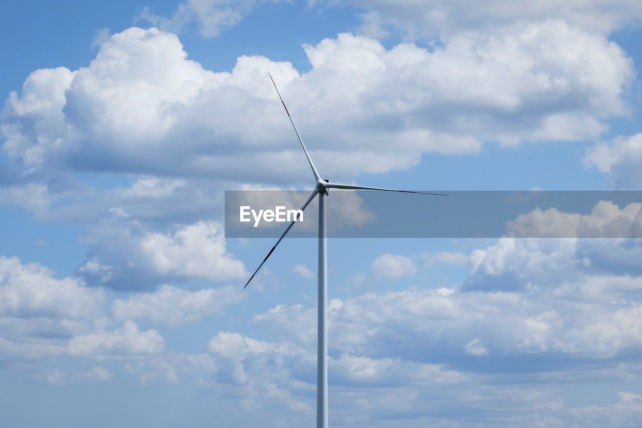 Low angle view of wind turbine against cloudy sky