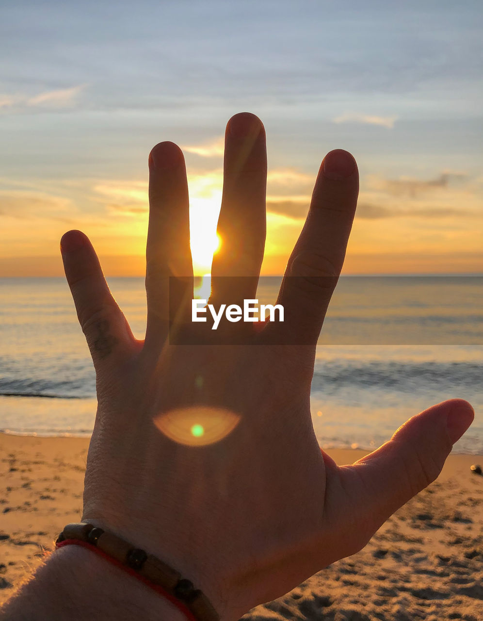 CLOSE-UP OF HAND ON BEACH