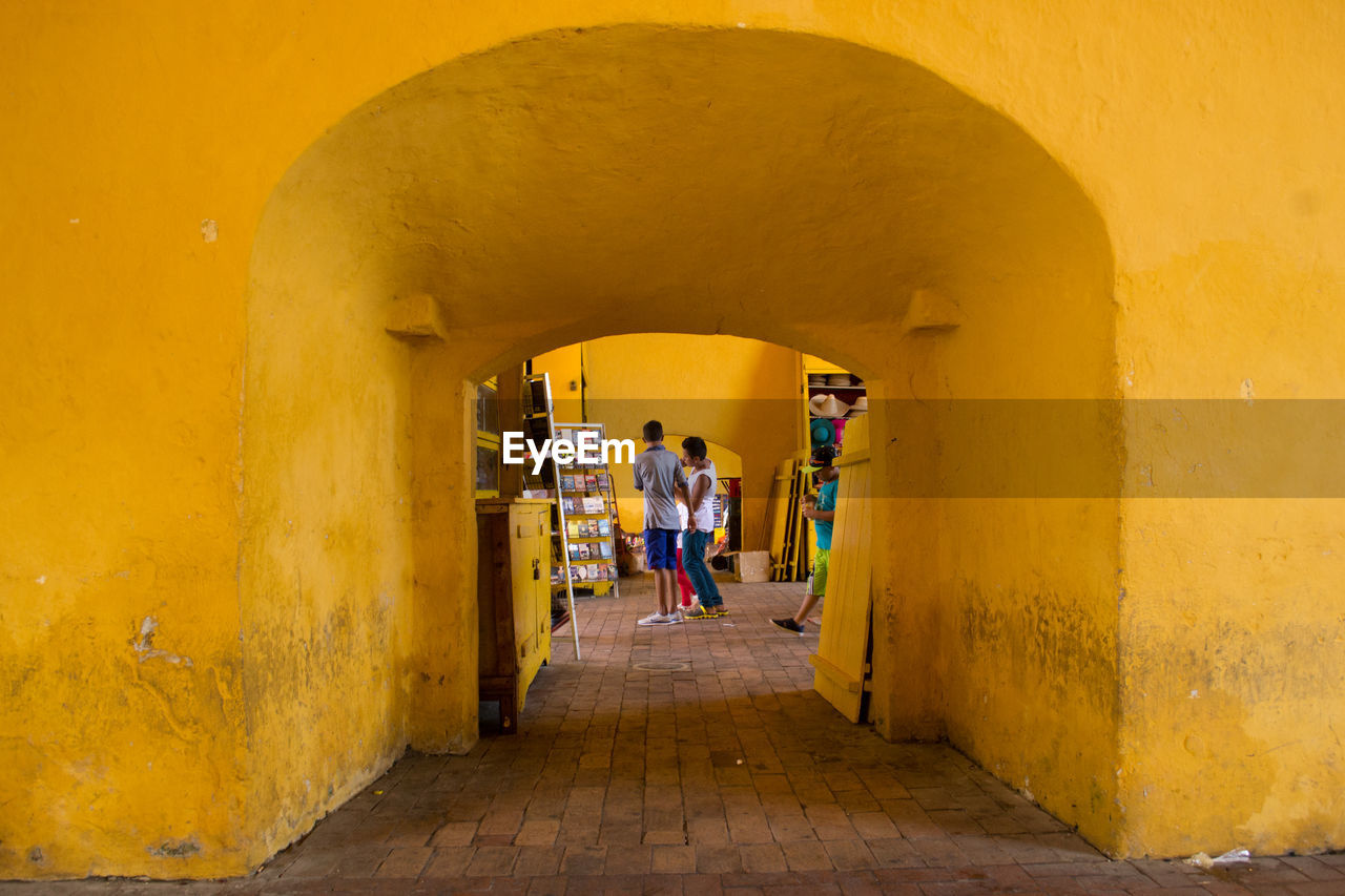 TOURISTS IN CORRIDOR OF BUILDING