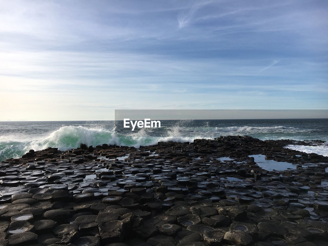 SEA BY ROCKS AGAINST SKY