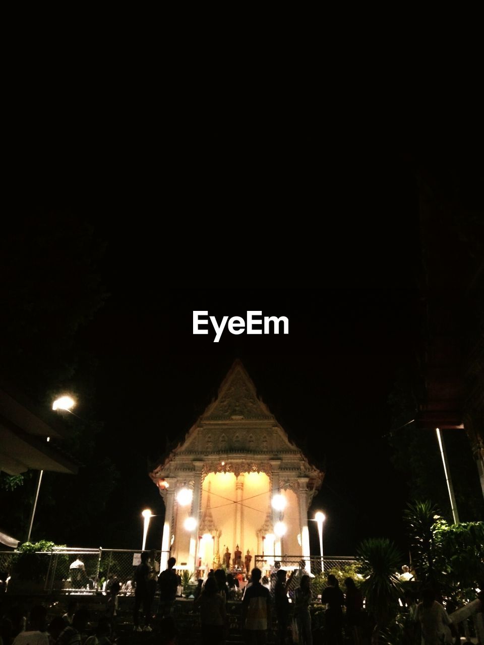 PEOPLE IN ILLUMINATED BUILDING AT NIGHT