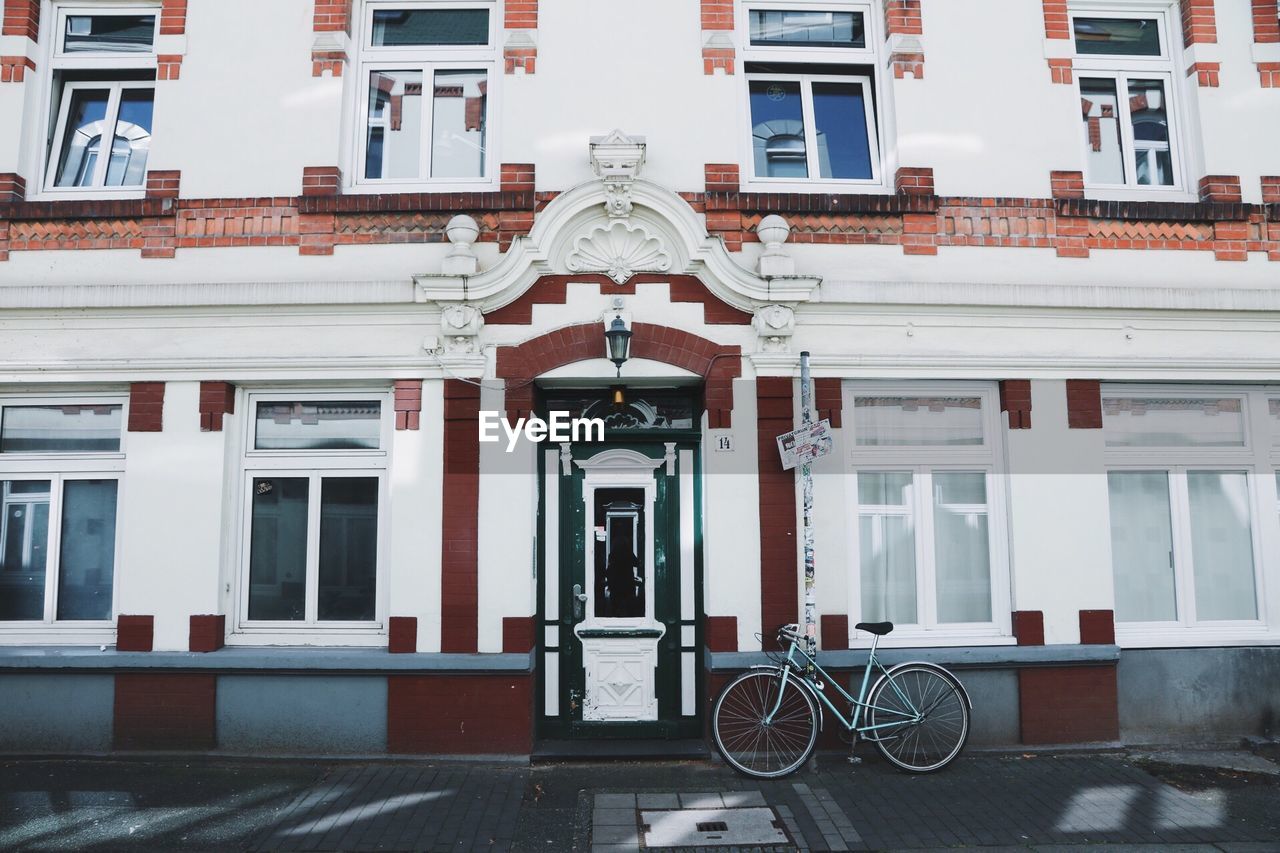 Bicycle parked against residential building