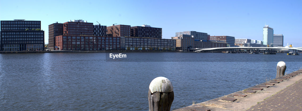 View of city by river against clear sky