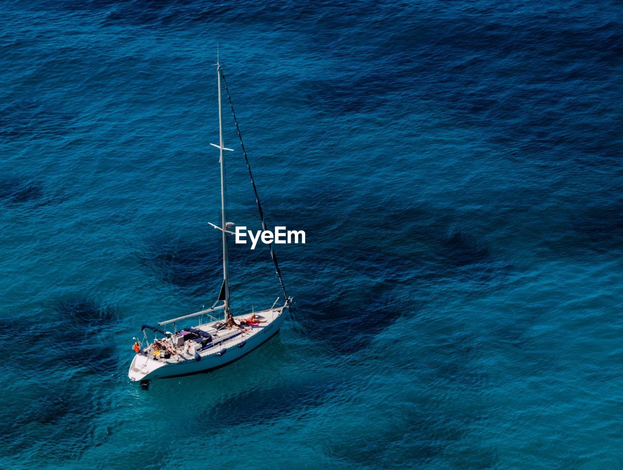 High angle view of sail boat in calm blue sea