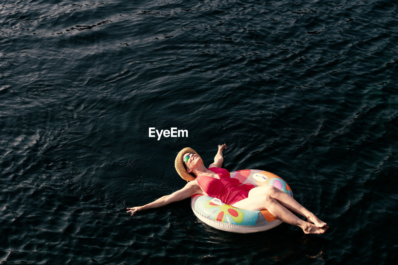 Woman on inflatable ring in lake