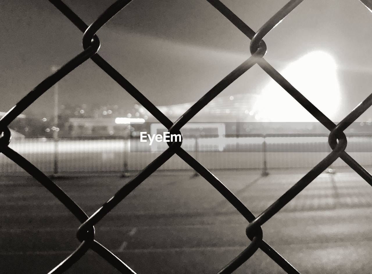 Full frame shot of wet chainlink fence against sky