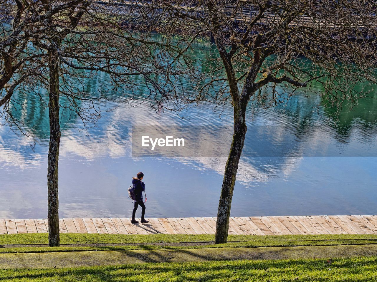 Rear view full length of person walking by lake