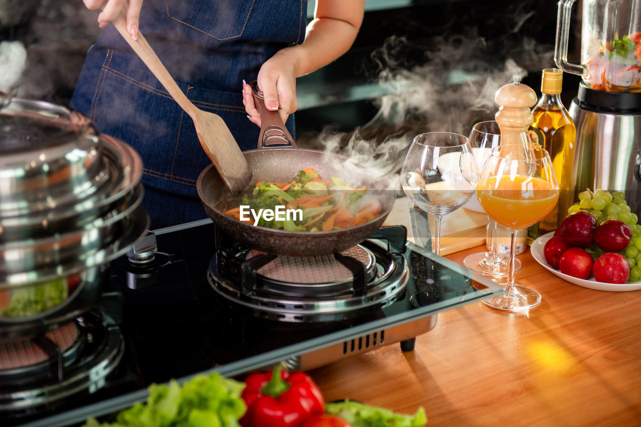 midsection of person preparing food in kitchen