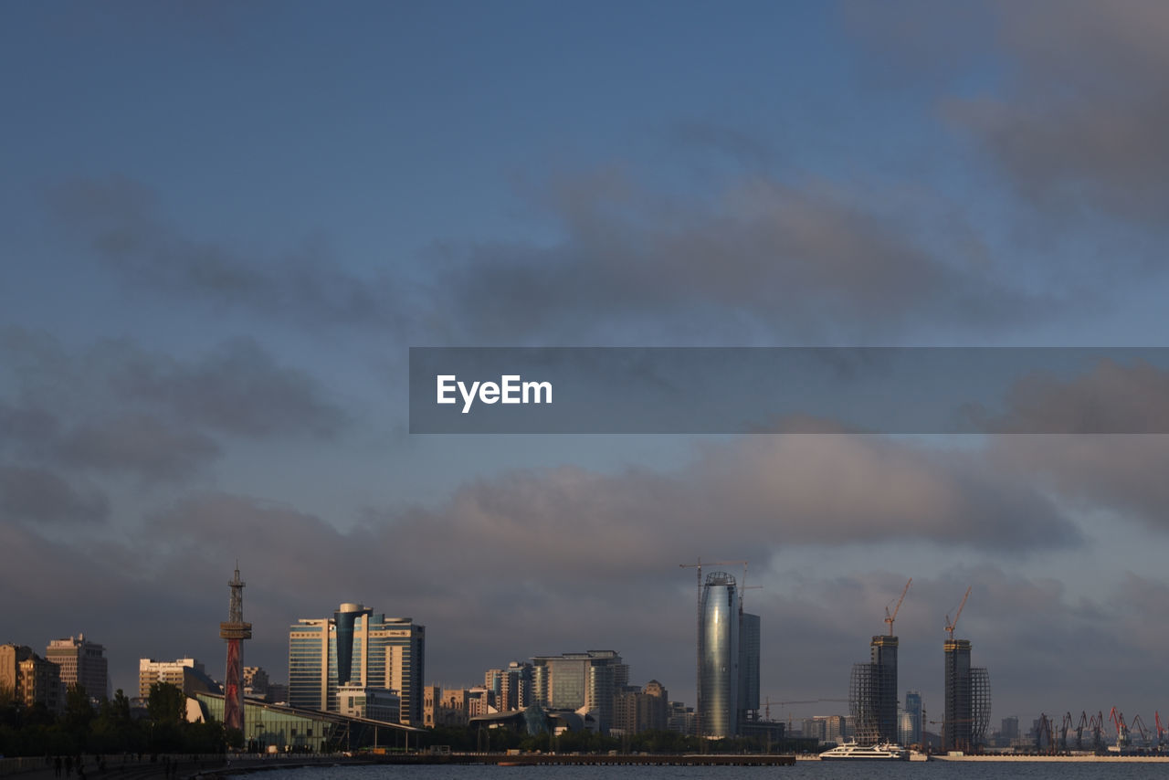 View of cityscape against cloudy sky