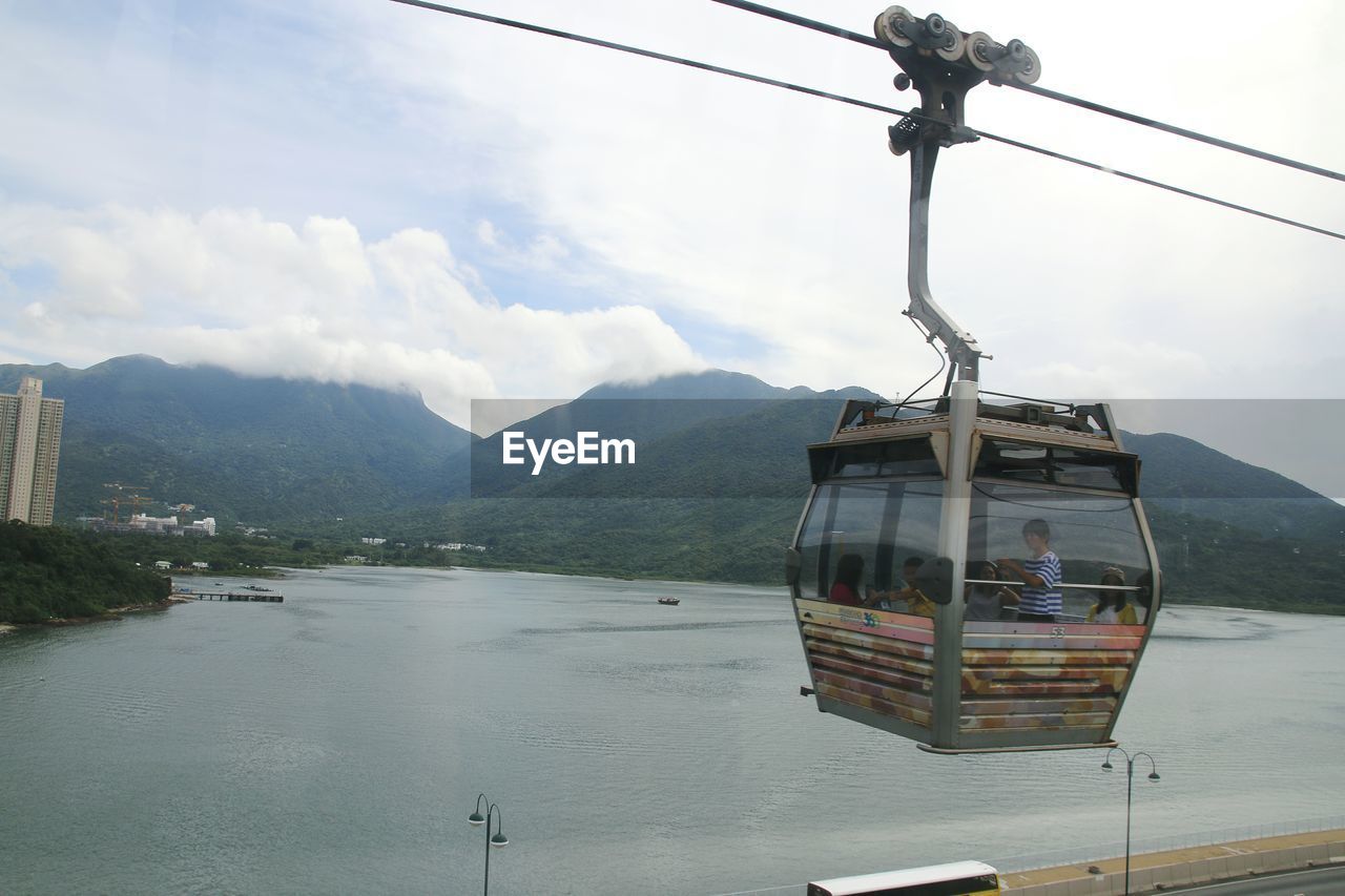 Overhead cable car over lake against sky