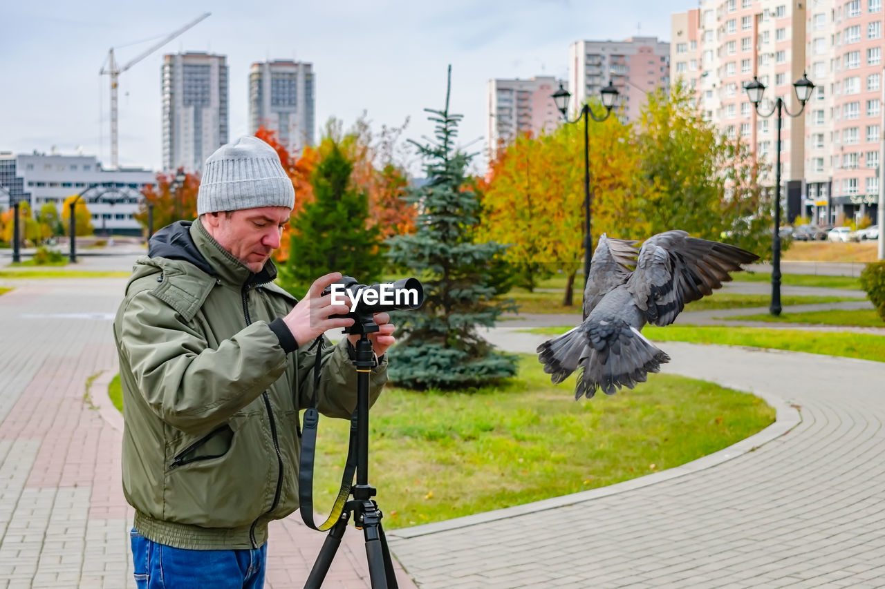 Photographer takes pictures of birds in the park in autumn