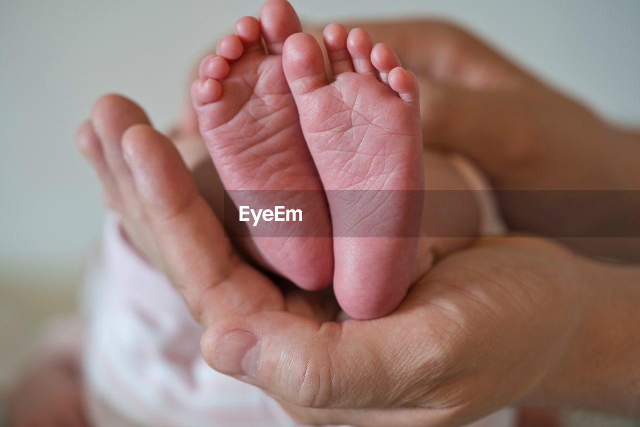 Close-up of baby feet on daddy hand