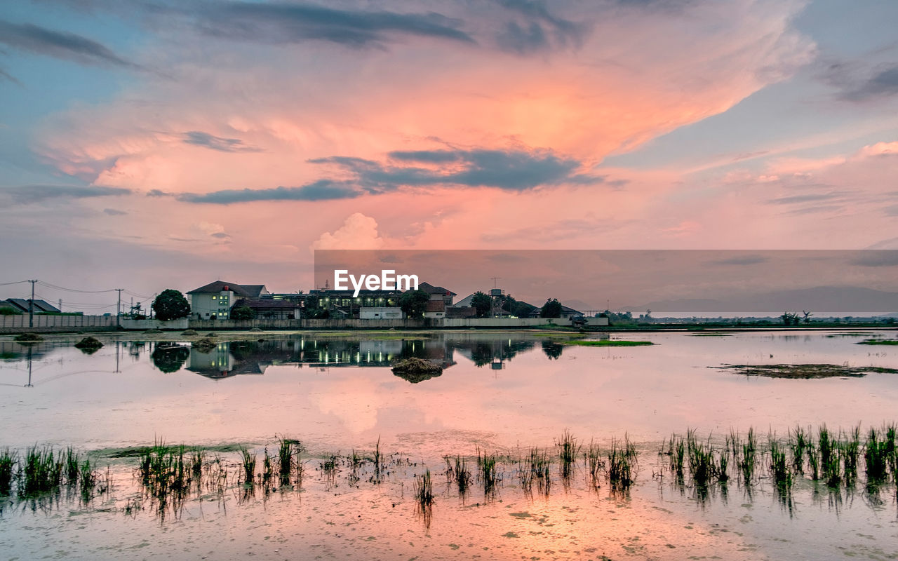 Scenic view of lake against sky at sunset