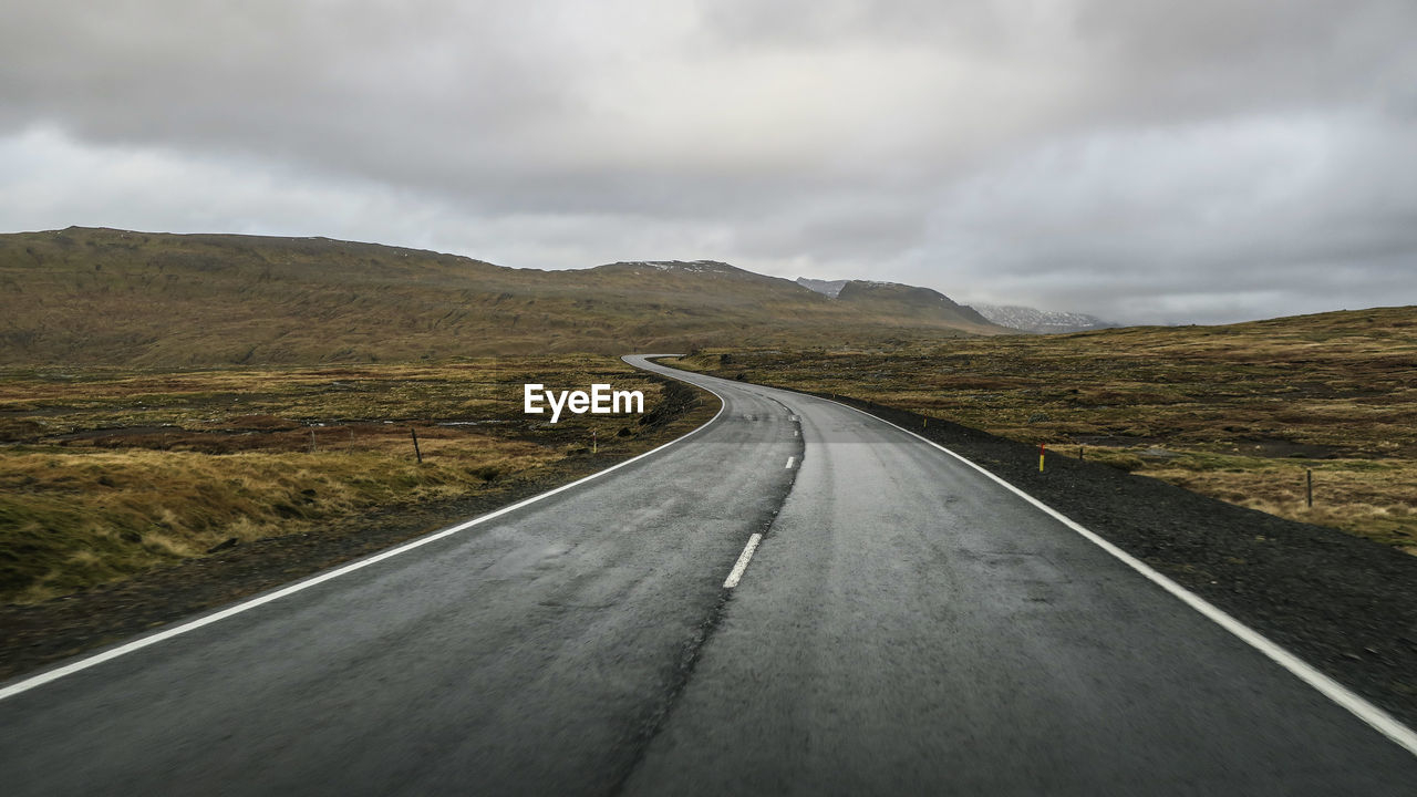 Empty road against cloudy sky