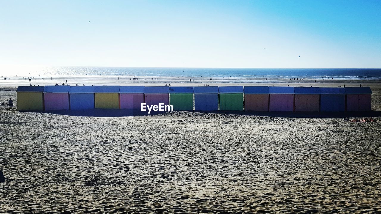 Multi colored umbrellas on beach against clear sky