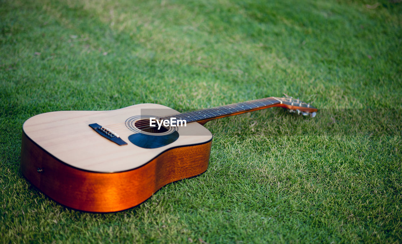 Close-up of guitar on grassy field