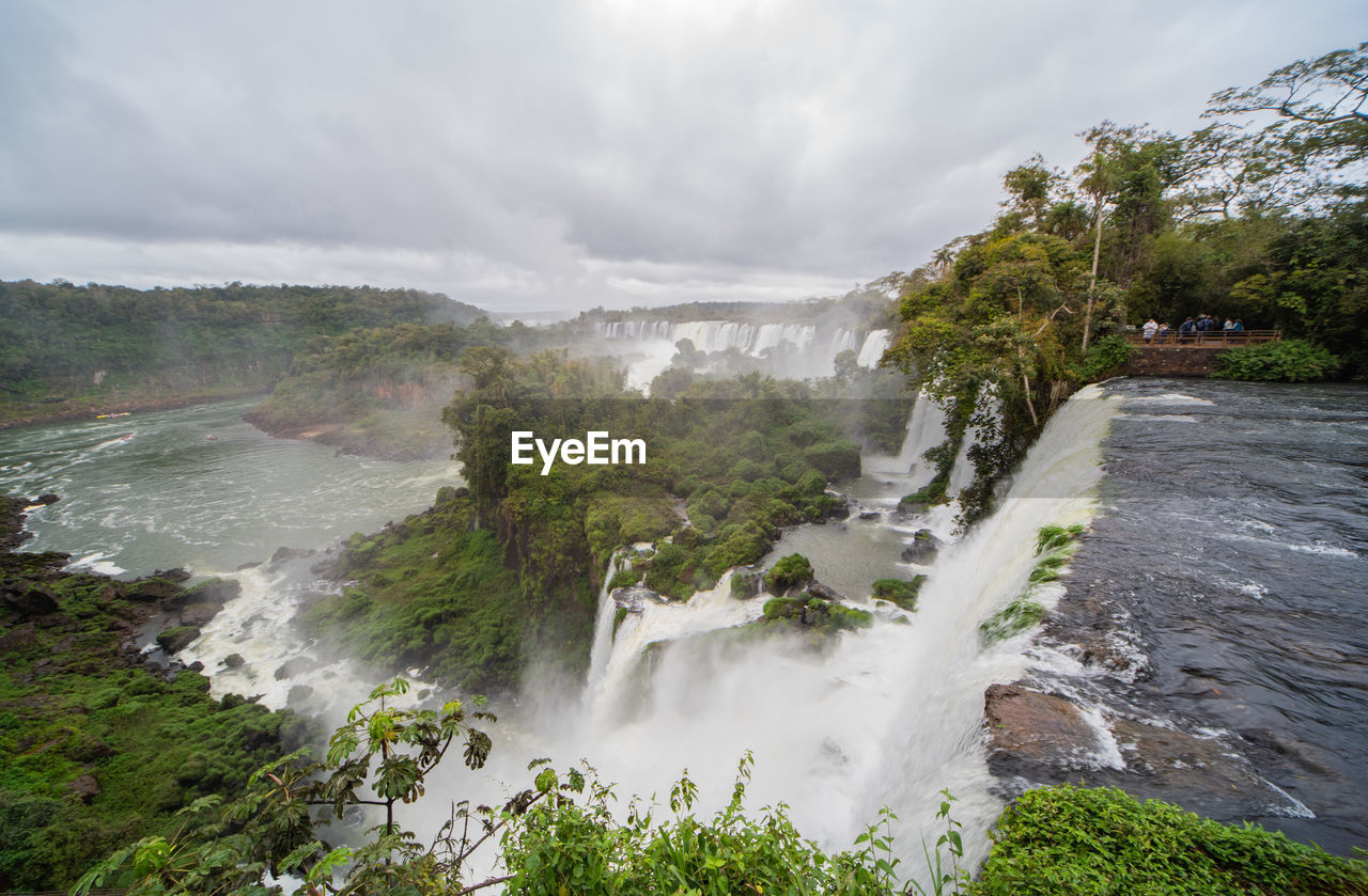 SCENIC VIEW OF WATERFALL AGAINST TREES AND SKY