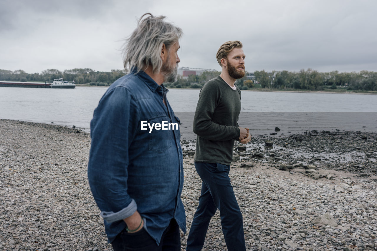 Father and son taking a stroll at rhine river, meeting to talk