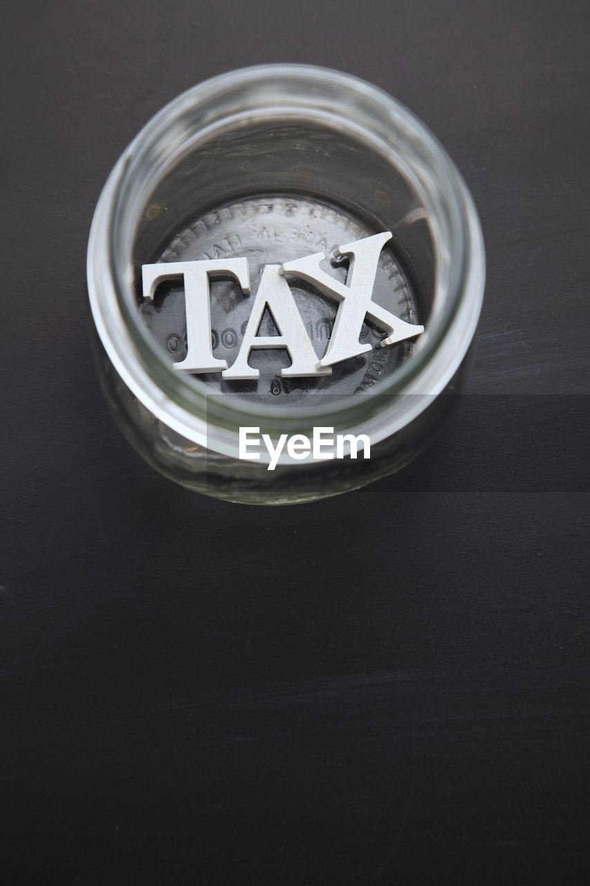 High angle view of tax text in container on black background