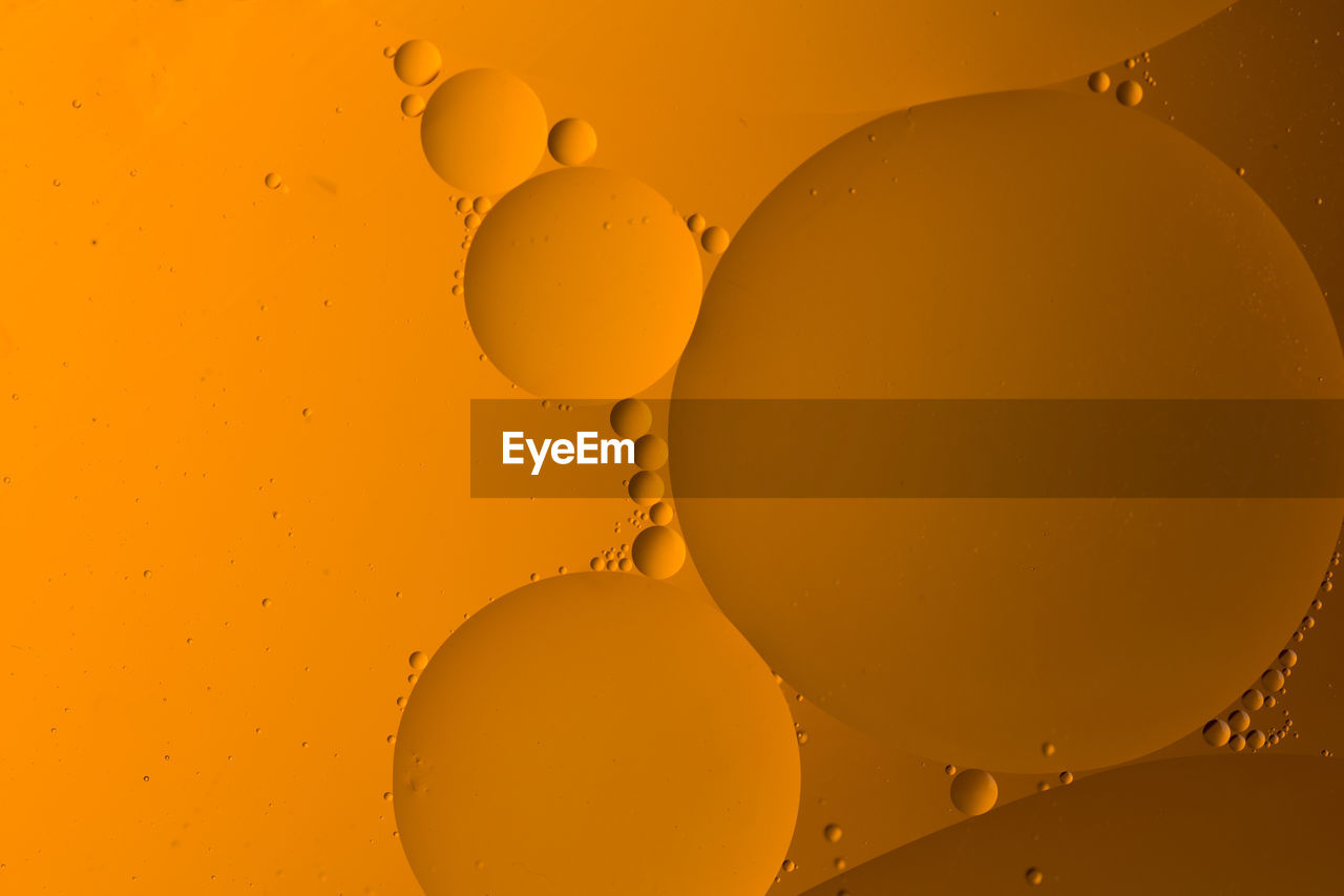 Abstract background of yellow oil drops on water