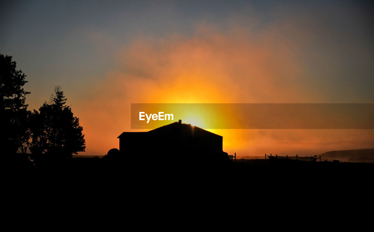 Silhouette buildings against sky during sunset