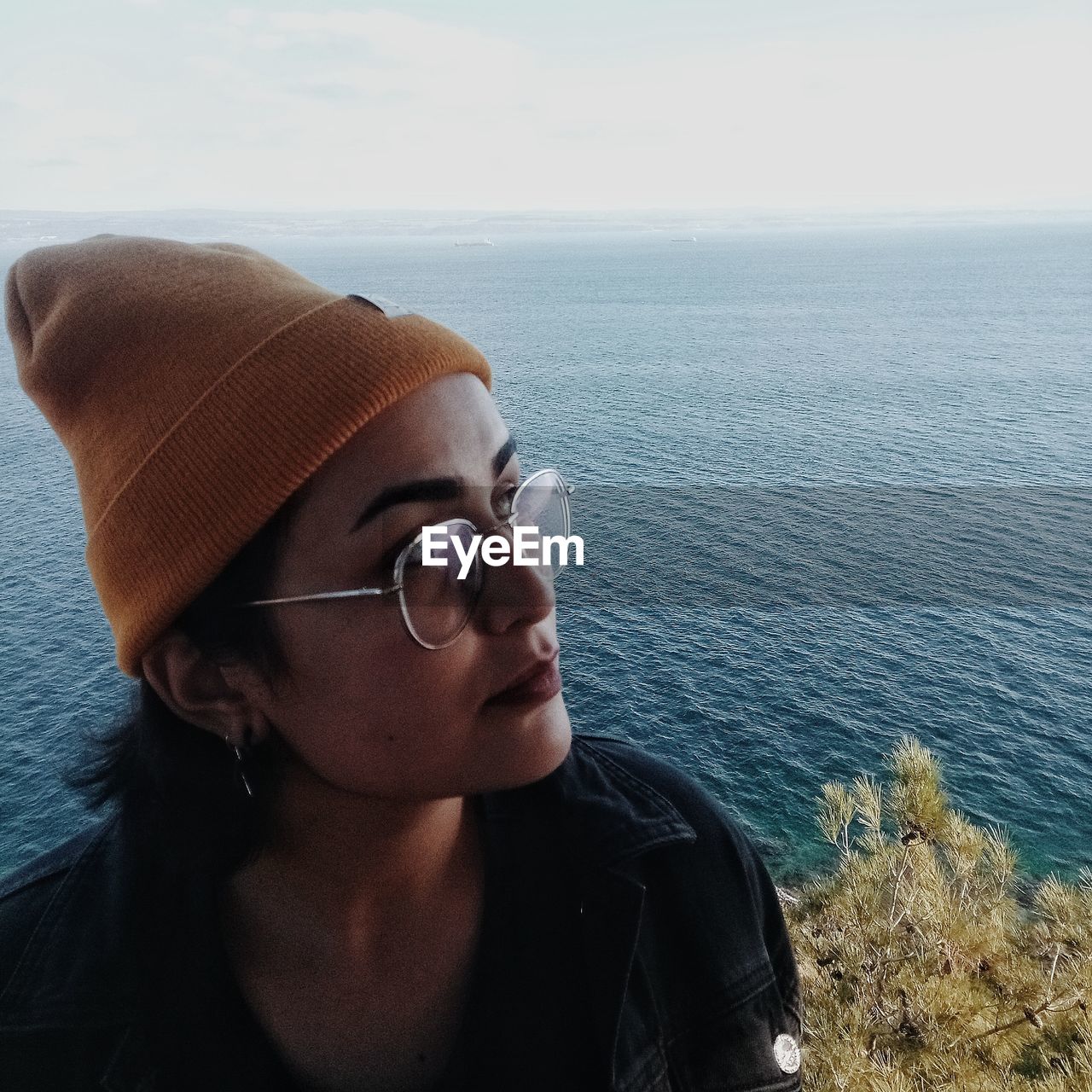 Woman wearing sunglasses against sea and sky