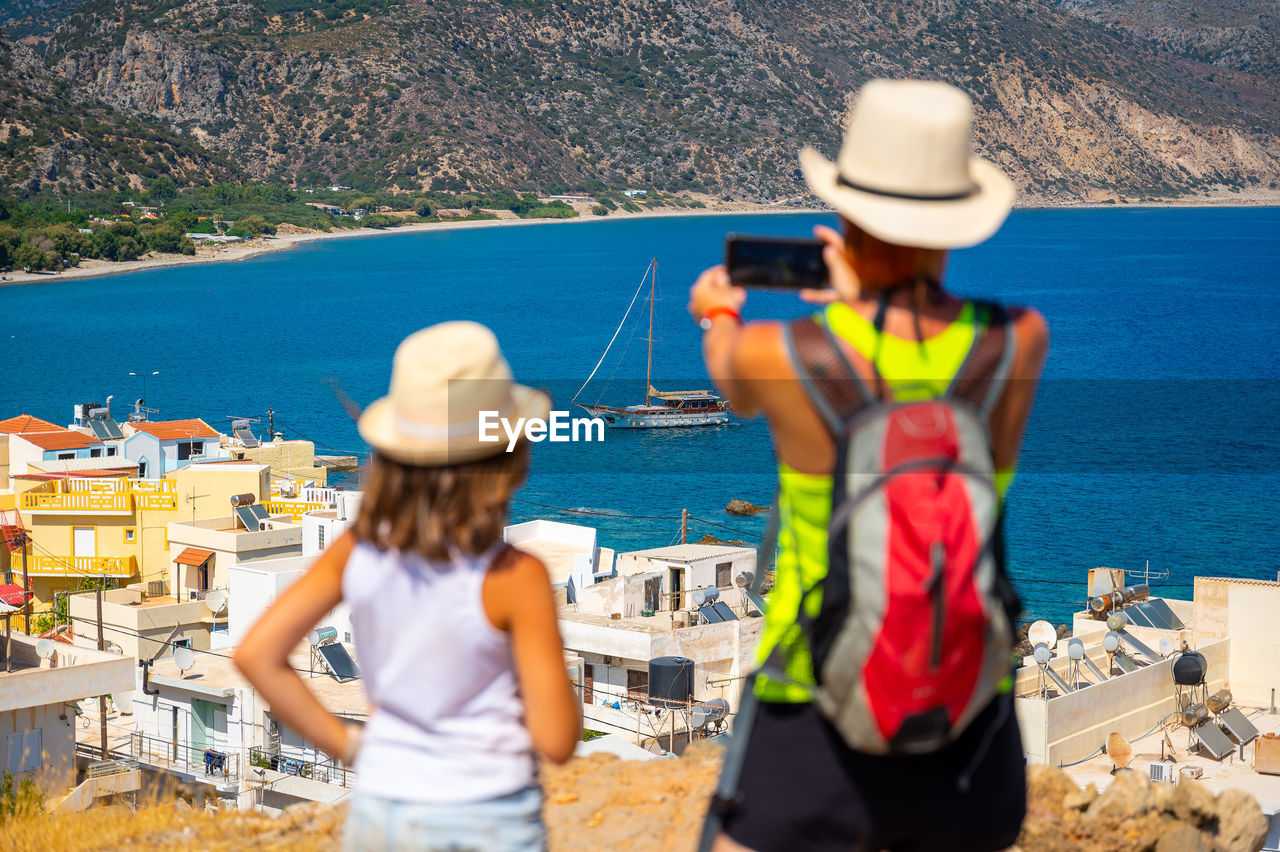 rear view of friends standing on beach