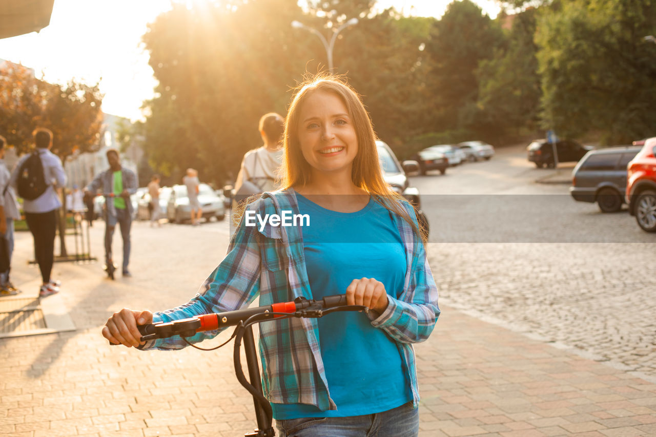 portrait of young woman standing on road