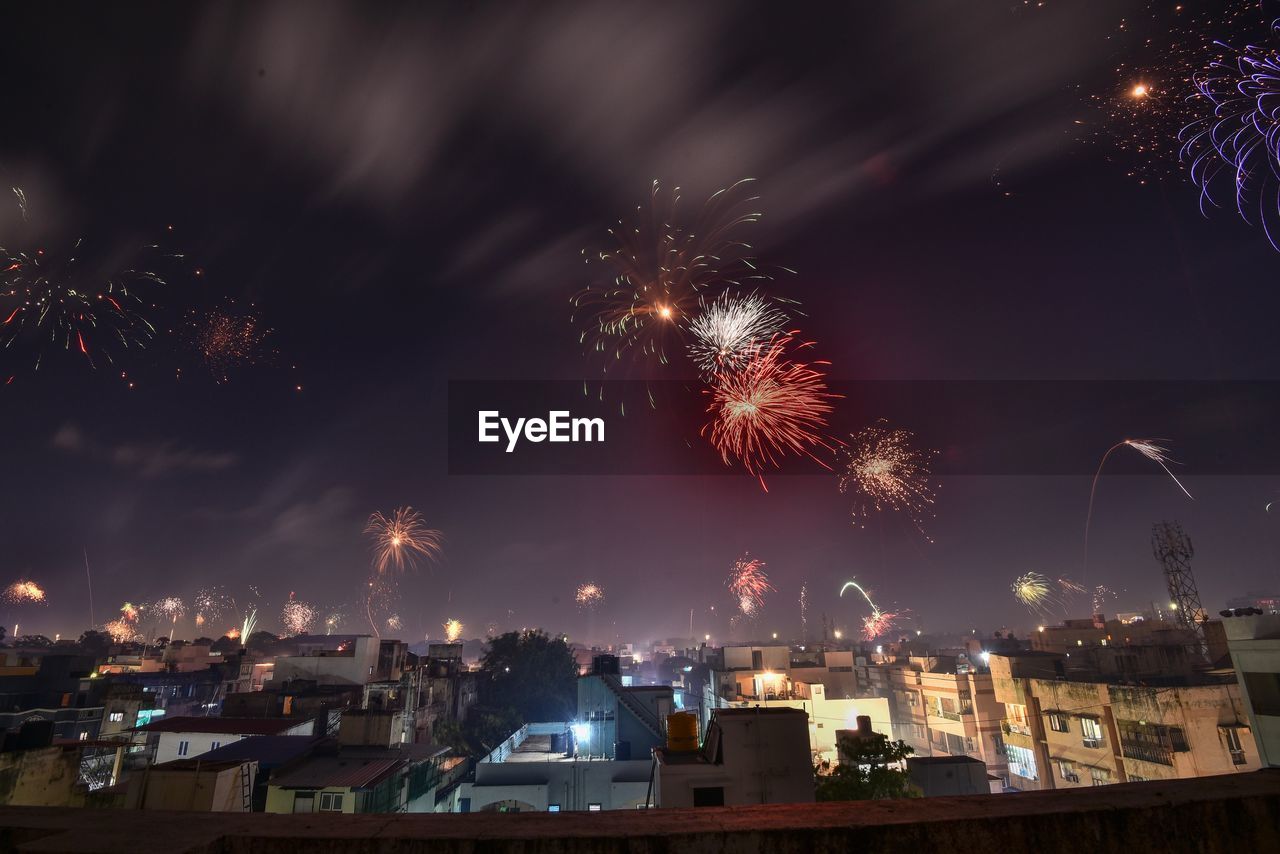 FIREWORK DISPLAY OVER ILLUMINATED BUILDINGS IN CITY