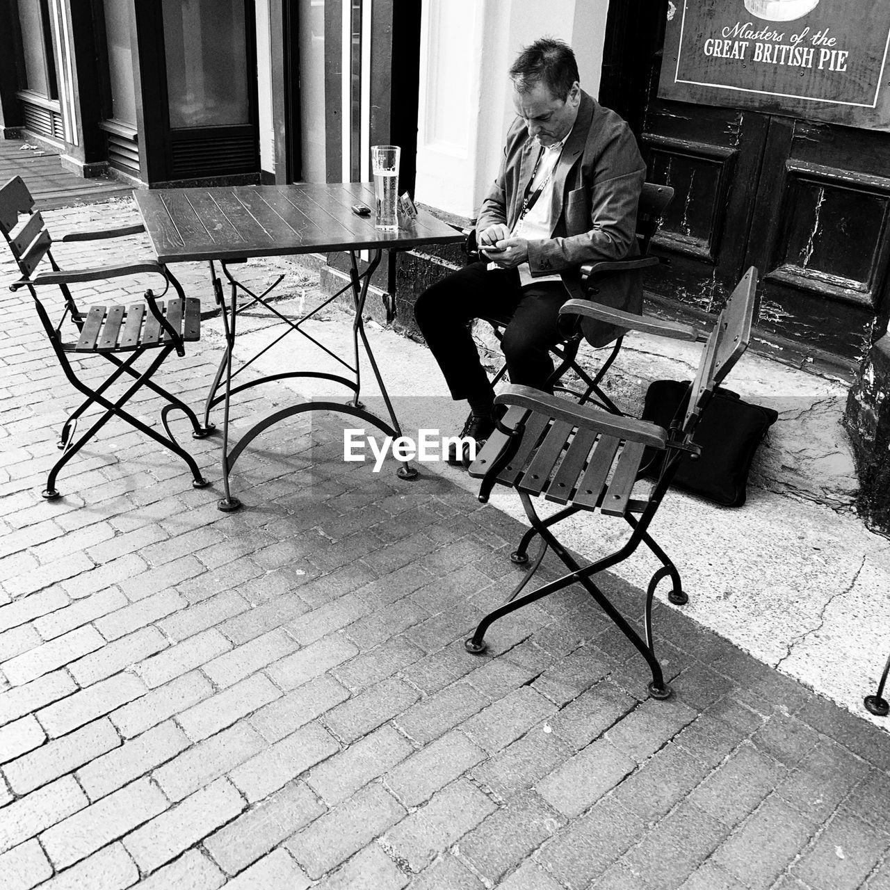 YOUNG MAN SITTING ON CHAIR OUTDOORS