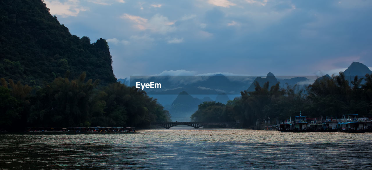 Scenic view of lake by mountains against sky