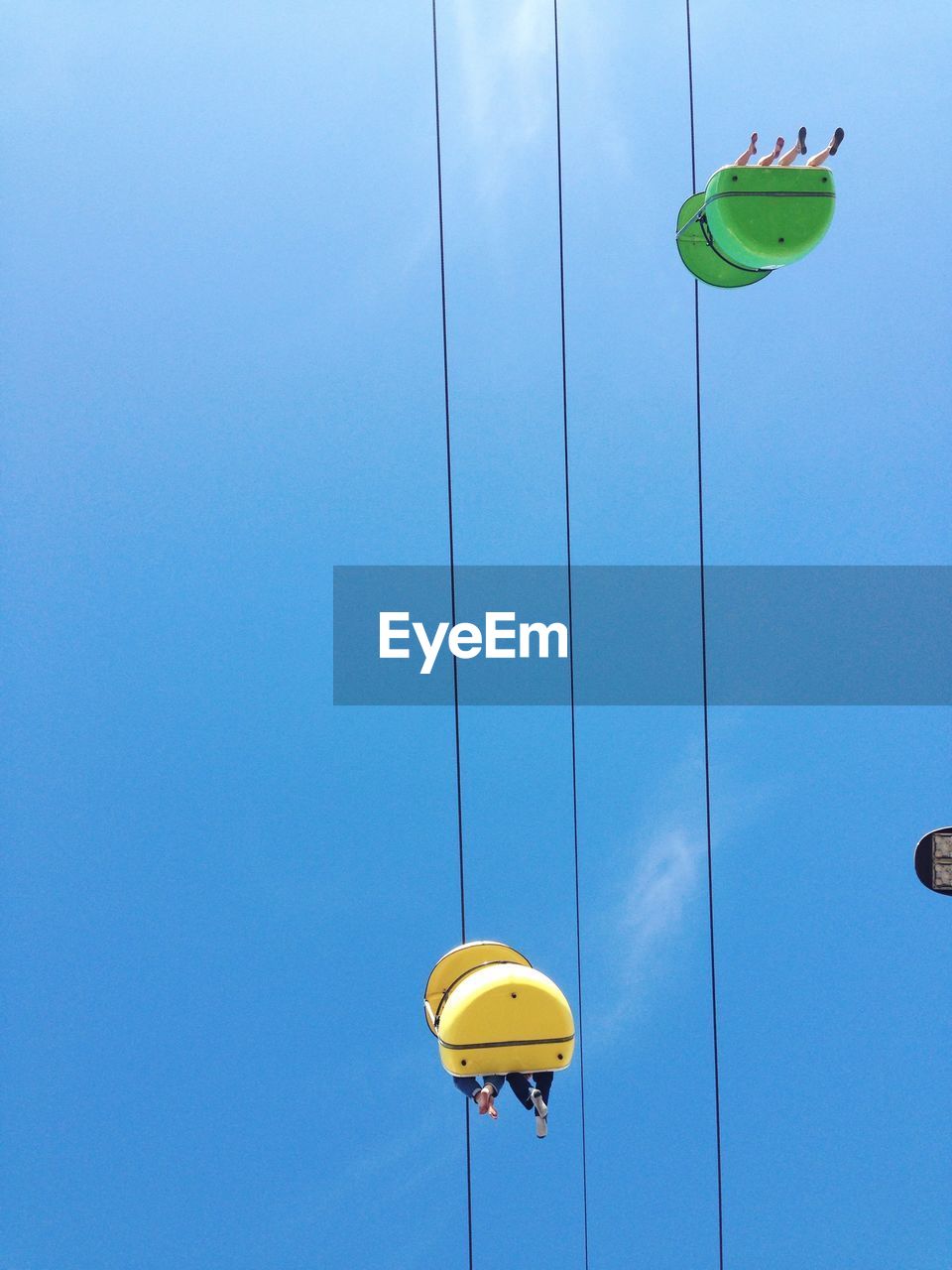 Low angle view of people traveling on ski lift against sky