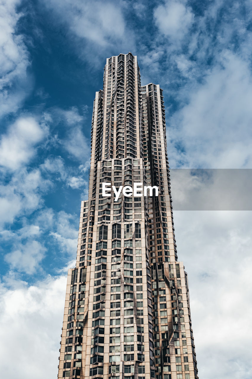 Low angle view of modern building against cloudy sky