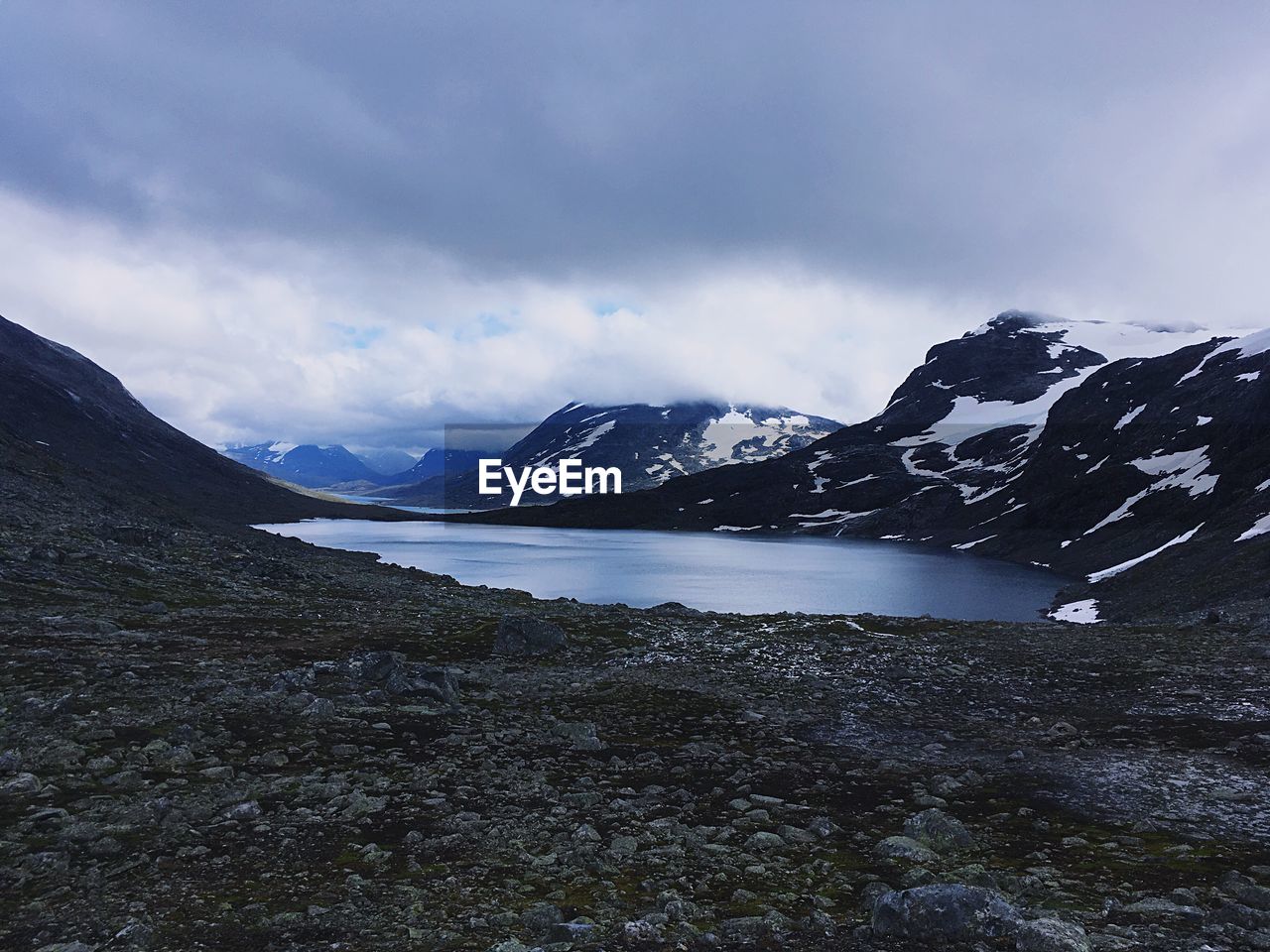 Scenic view of lake by mountains against sky