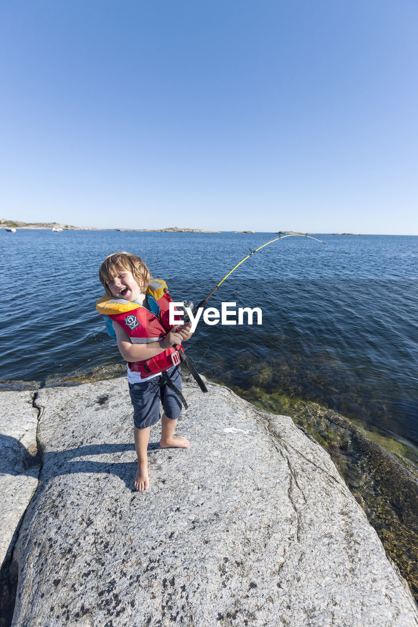 Happy boy fishing in sea