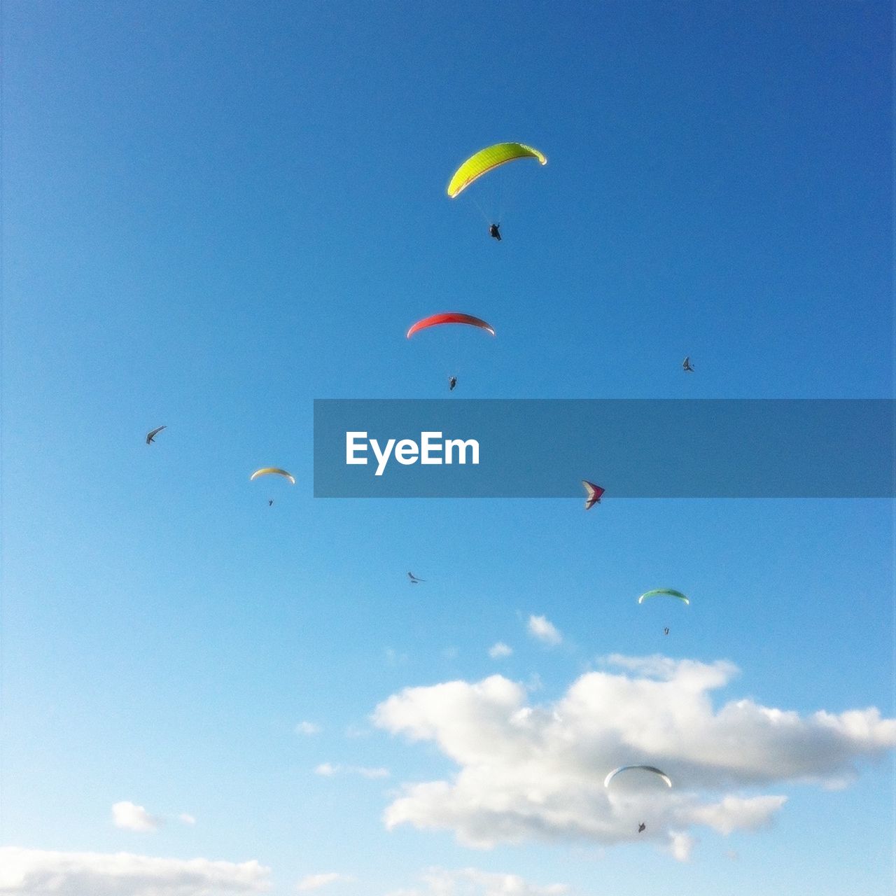 Paragliders flying against sky