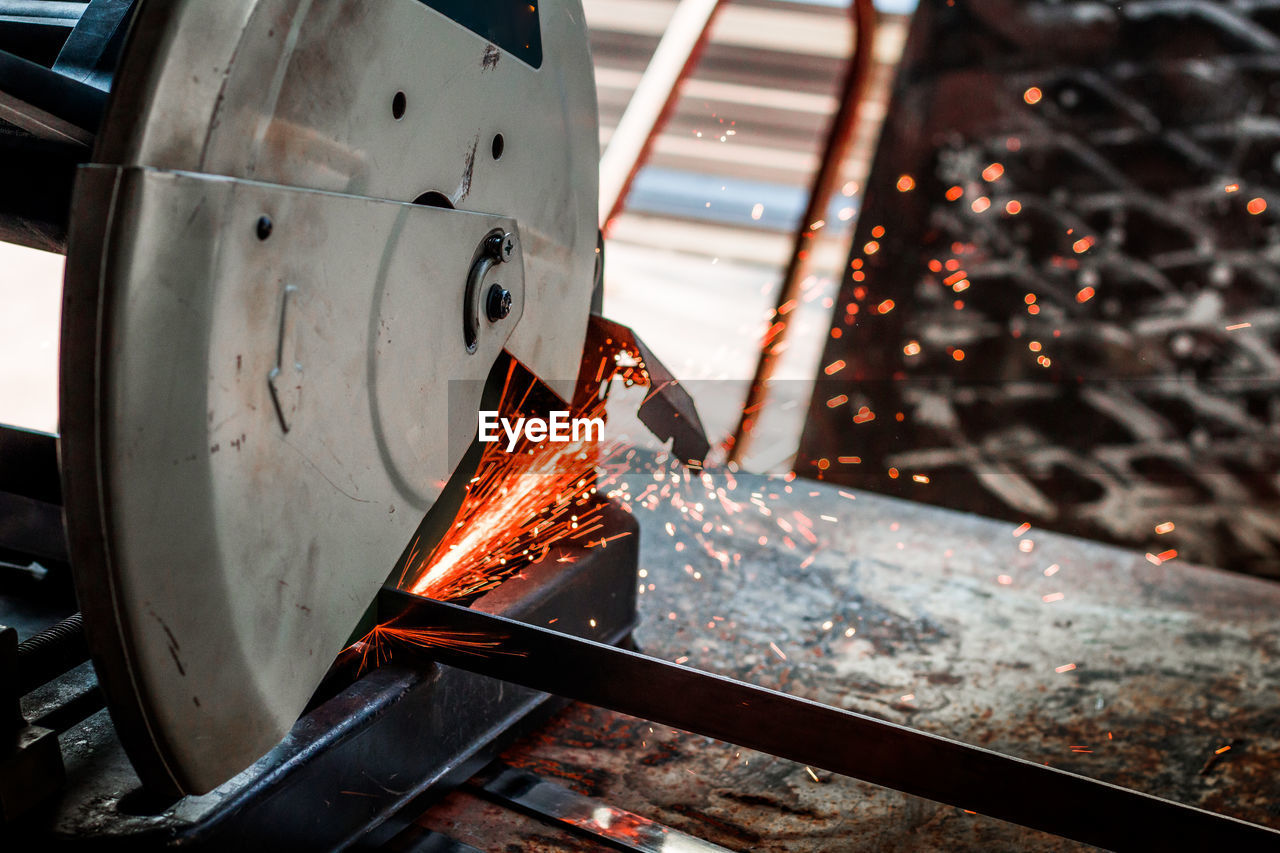 Close-up of electric saw cutting metal in factory