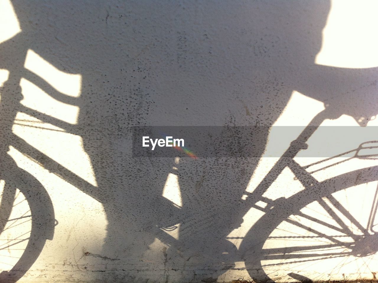 Shadow of person and bicycle on wall