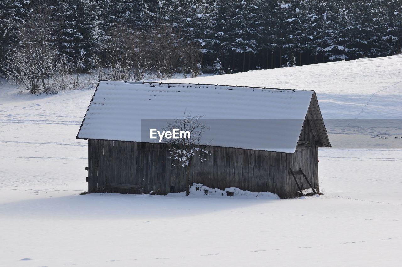 BUILT STRUCTURE ON SNOW FIELD AGAINST SKY