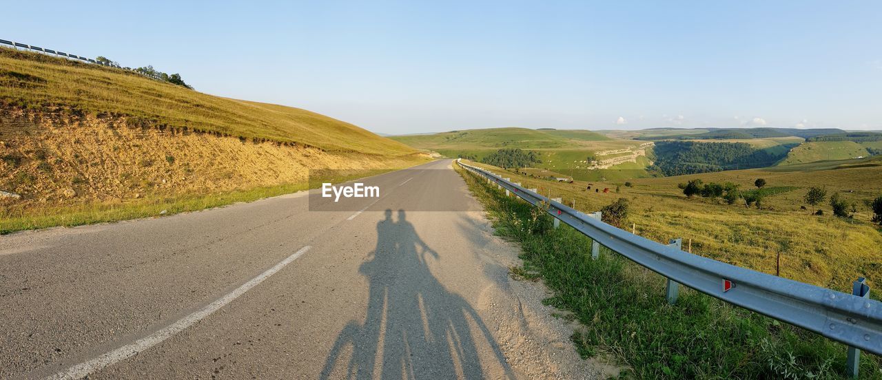 EMPTY ROAD ALONG COUNTRYSIDE LANDSCAPE