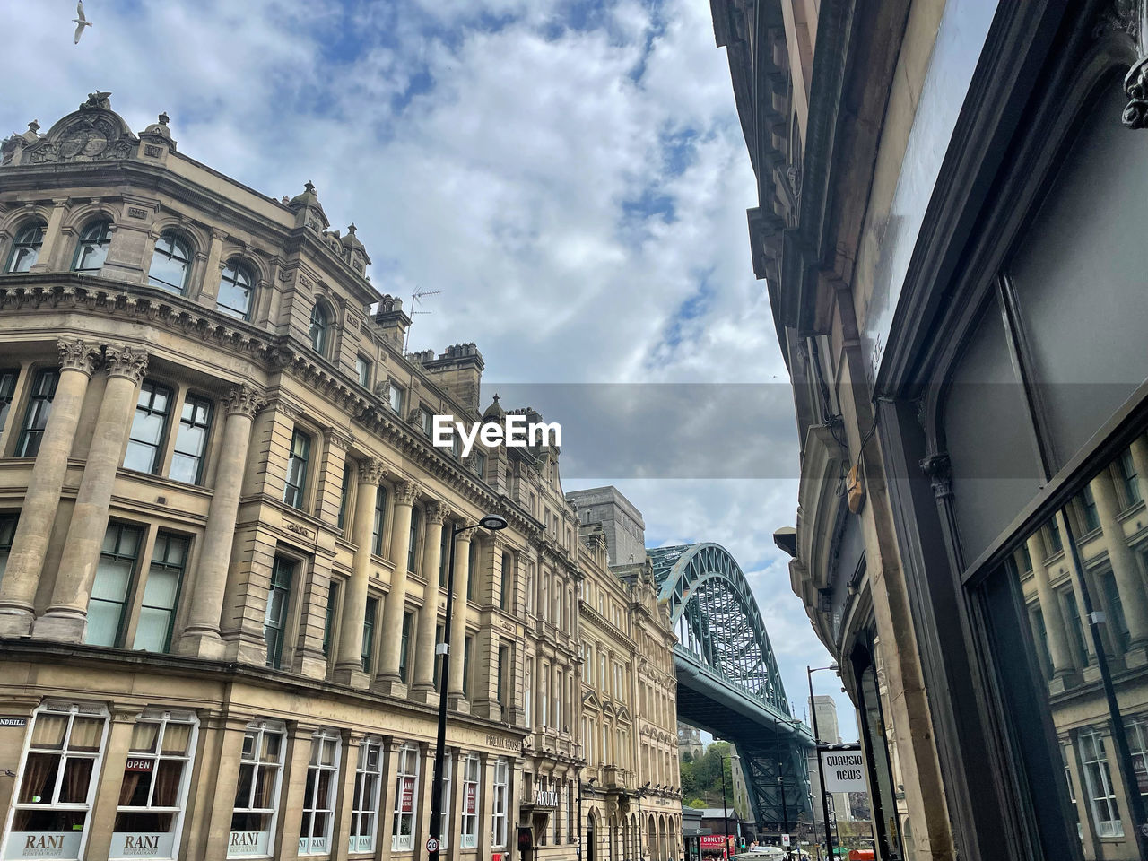 architecture, building exterior, built structure, city, urban area, cityscape, landmark, downtown, road, metropolis, sky, street, facade, building, travel destinations, cloud, neighbourhood, metropolitan area, travel, the past, low angle view, history, city life, nature, skyscraper, day, city street, transportation, tourism, window, town, outdoors, mode of transportation, group of people, residential district
